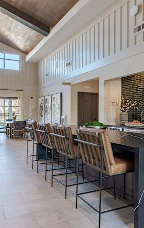 an open kitchen with a granite counter top and stools