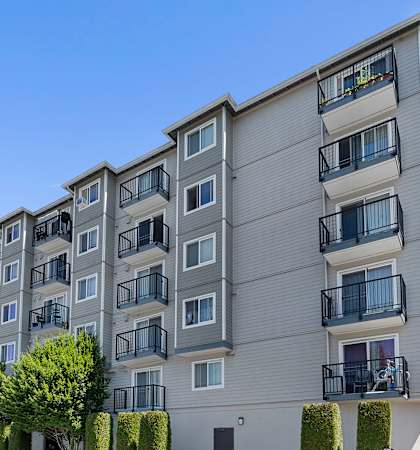 a picture of an apartment building with cars parked in front of it at King Arthurs Court, Washington