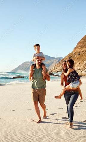 A family of three is walking on a beach.