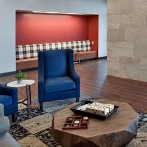 A modern living room with a blue chair and a coffee table.