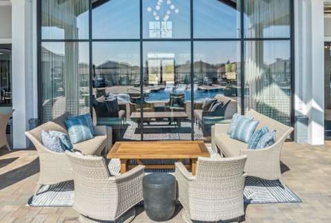 A patio with a table and chairs is set up outside a building. at The Lofts at Town Madison, Madison, AL, 35758