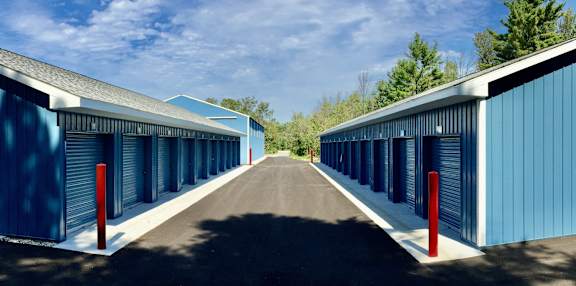 A long row of blue storage units with red posts at the end.