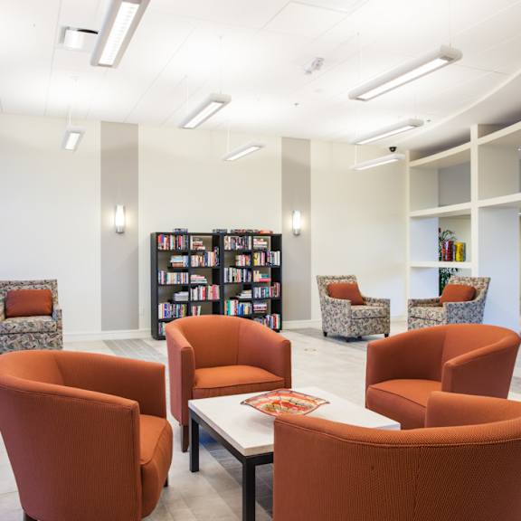 A room with orange chairs and a white table at Hummingbird Pointe & The Gardens, Parma, 44129