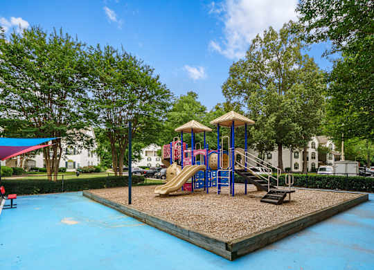 A playground with a blue slide and a wooden platform.