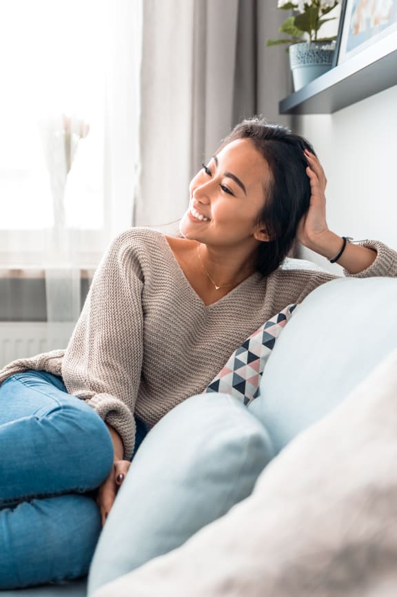a woman sitting on a couch with her hand on her head at 44 West Luxury Living, Valley Park