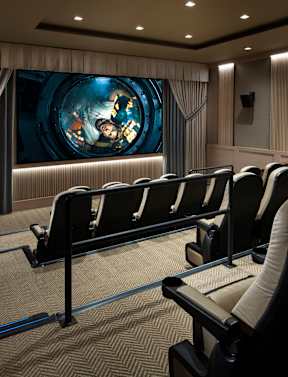 A movie theater with rows of seats facing a large screen.