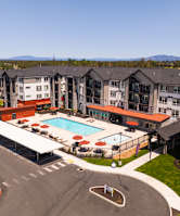 A large apartment complex with a pool and parking lot.