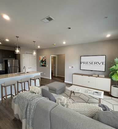 A modern living room with a grey couch and a bar area.