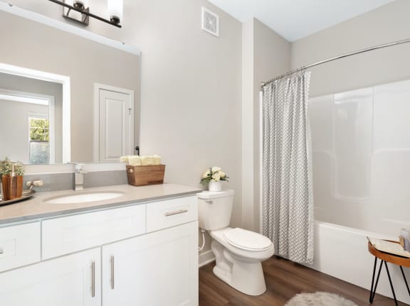 a bathroom with a white sink and toilet next to a white bathtub with a shower curtain at The Retreat Apartments, Virginia, 24019