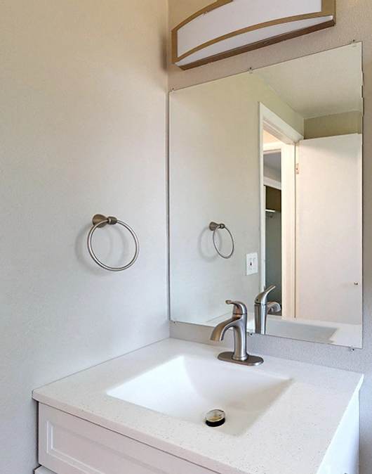 A white sink with a mirror above it.
