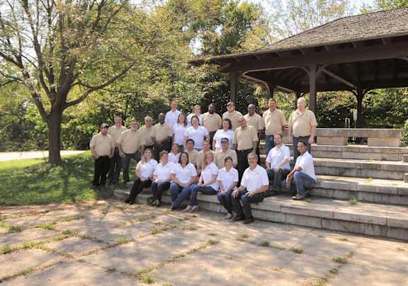 a group of people posing for a picture in front of a pavilion