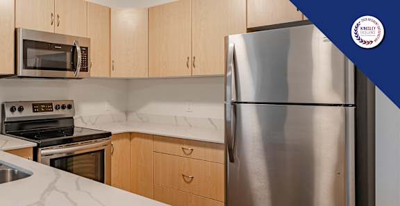 A kitchen with a stainless steel refrigerator, sink, and oven.