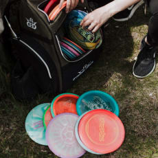 Man Packing Frisbees into Backpack