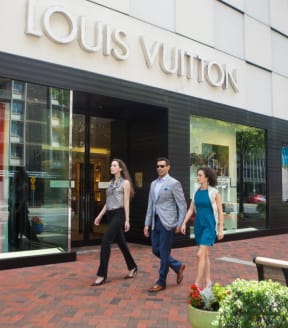 people walking in front of a louis vuitton store