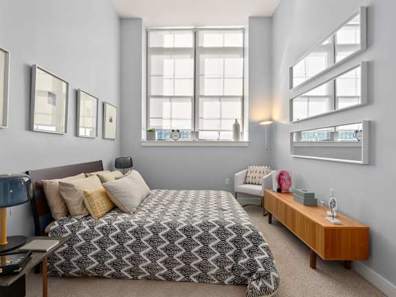 A bedroom with a large bed and a window.