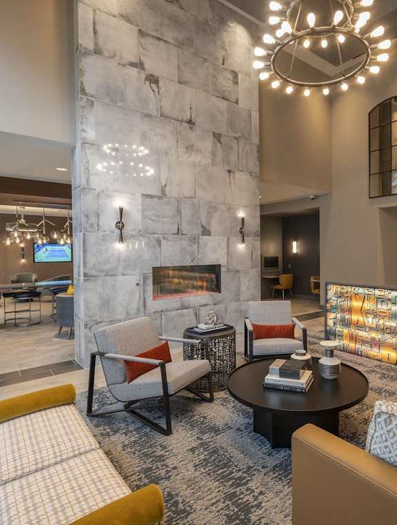 A modern living room with a stone fireplace and a large sectional sofa.