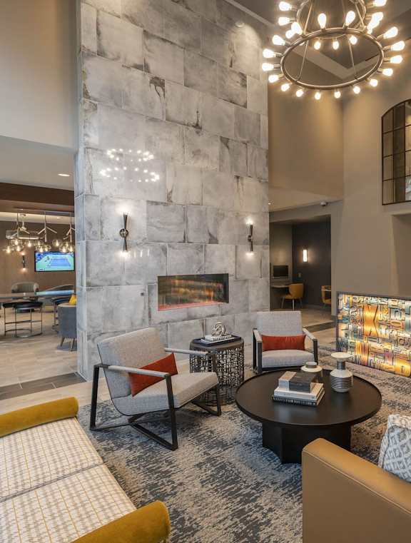 A modern living room with a stone fireplace and a large sectional sofa.