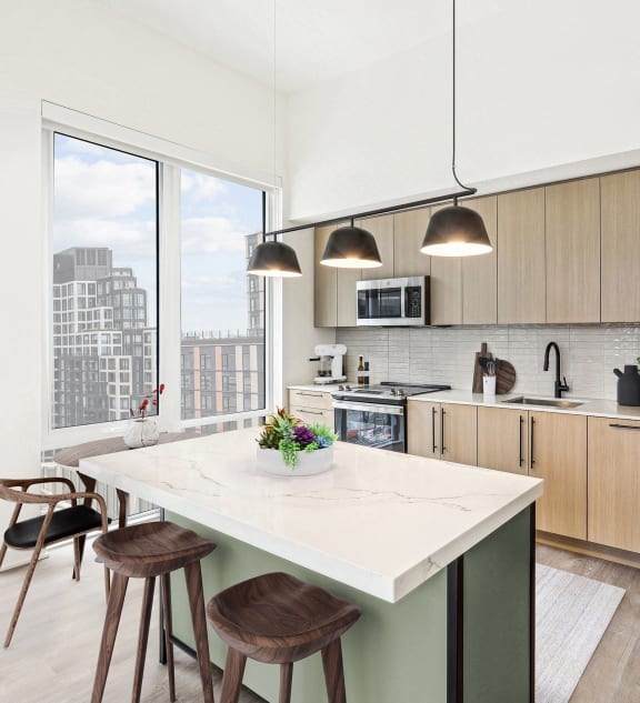 a kitchen with a large island and a stainless steel refrigerator