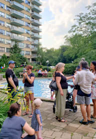 people gathered around a pool at a party in a garden