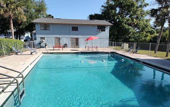 A swimming pool with sparkling blue water and a building in the background.