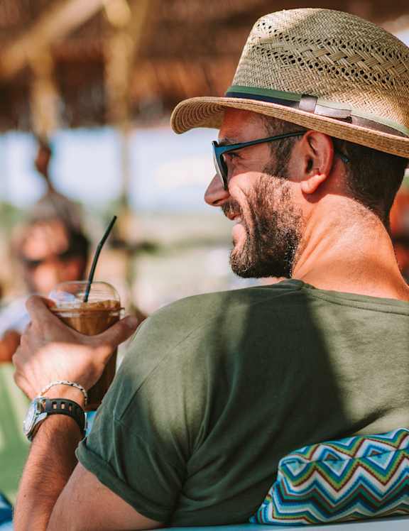a man in a hat and sunglasses drinking a drink at Paramount on Lake Eola, Florida, 32801