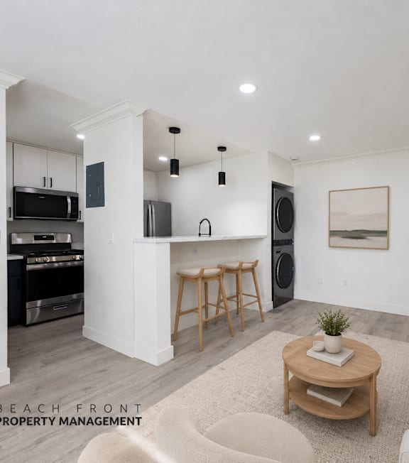 A well-lit, modern kitchen and living room with a dining area.