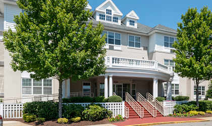 an apartment building with cars parked in front of it  at Walkover Commons, Brockton, MA