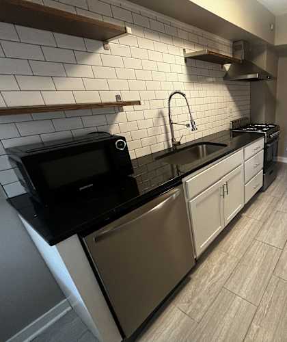 a view of the kitchen from the corner of the room with a sink and a