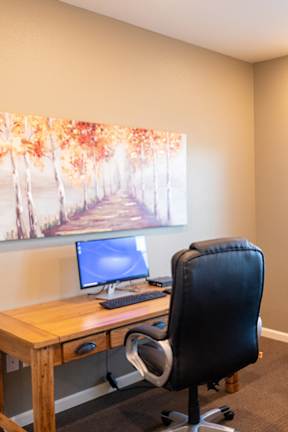 A room with wooden flooring and a window with blinds.