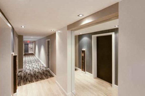 a hallway with white walls and a wooden floor at 1841 Columbia Road Apartments, Washington DC
