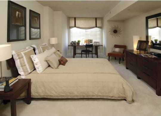 a bedroom with a large bed and a desk