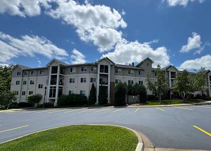 A large apartment complex with a grassy area in front.