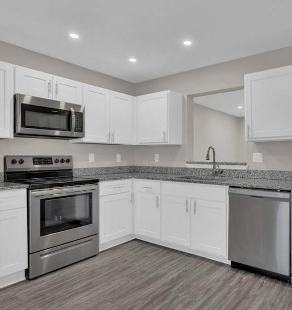 A modern kitchen with stainless steel appliances and white cabinets.