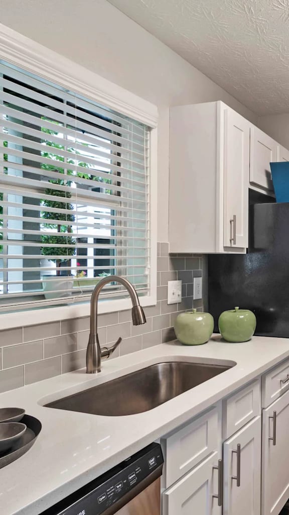 A kitchen with a sink and a refrigerator.