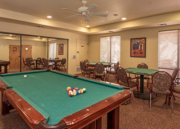 a large dining room with tables and chairs and windows at Winding Commons Senior Living, Carmichael