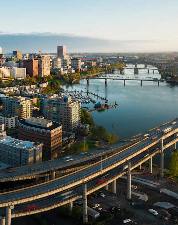 A cityscape with a bridge over a river.