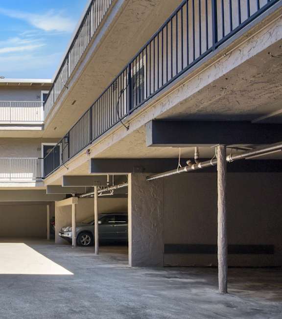 A parking garage with a clear blue sky visible through the windows.