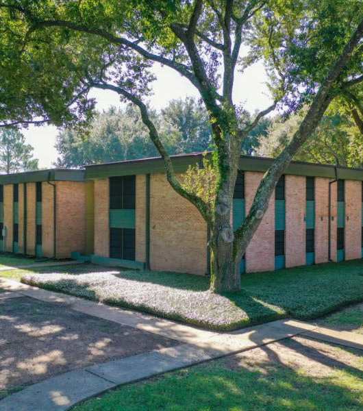 A building with a green lawn in front of it.