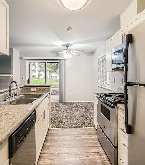 A kitchen with white cabinets and a granite countertop.