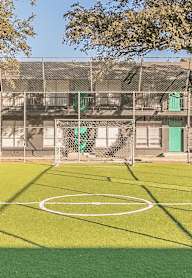 A green artificial turf soccer field with a white line in the middle.