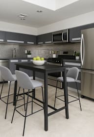 A kitchen with a table and chairs.