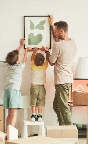 A man and two children are moving boxes in a room. at Hallwood Manor Apartments, Mentor, 44060