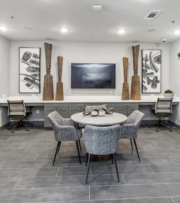 A modern room with a grey floor and a white table with chairs.