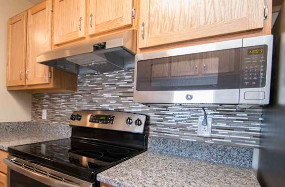 a kitchen with granite counter tops and a stove and microwave