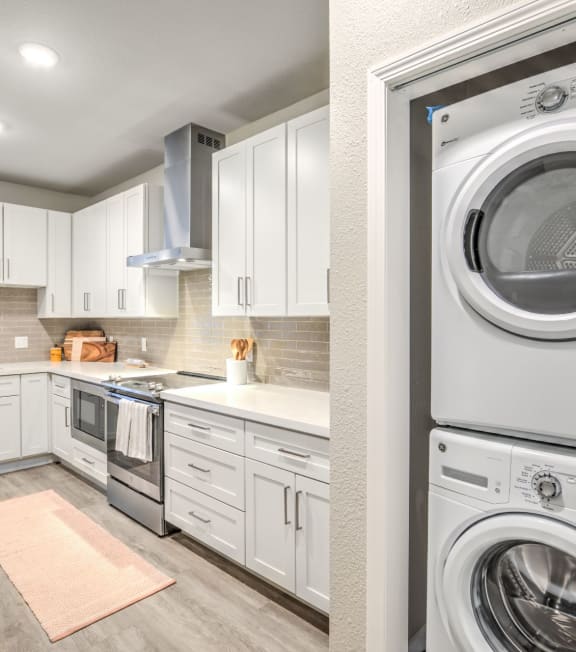 a white kitchen with a washing machine and a washer and dryer