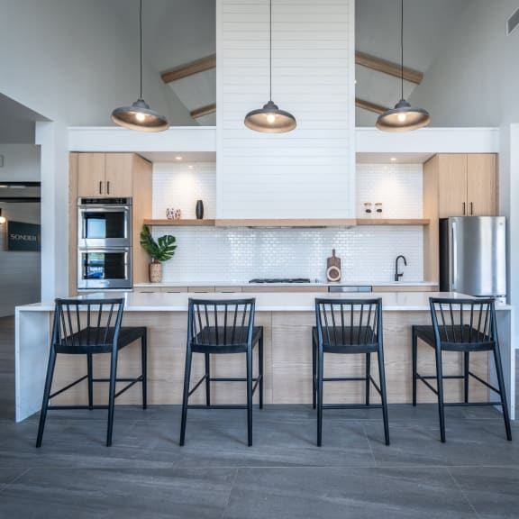 a kitchen with a large island with four stools in front of it at Sonder Fields in Happy Valley, OR