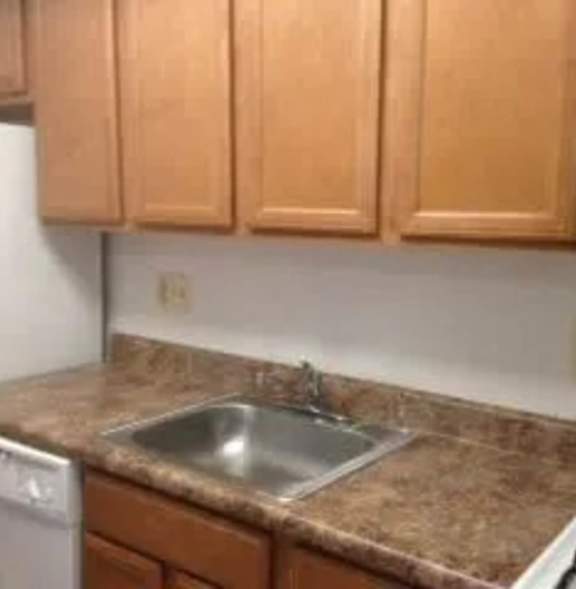 A family of three is cooking together in the kitchen.