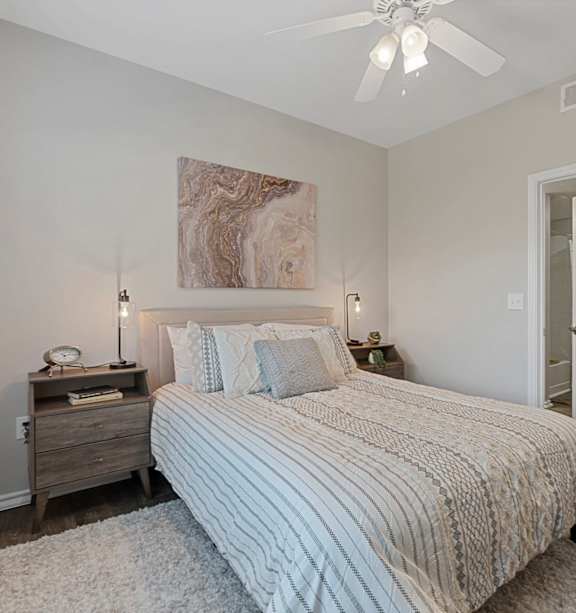 A bedroom with a large bed and a ceiling fan.