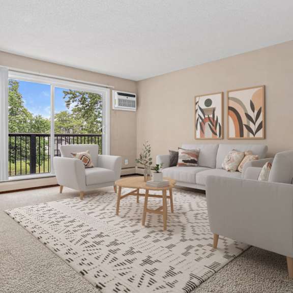 A living room with a grey couch, a coffee table, a television, and a large window with a view of a fence and trees.