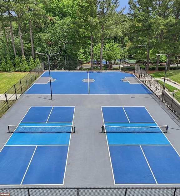 an aerial view of a tennis court with a fence around it